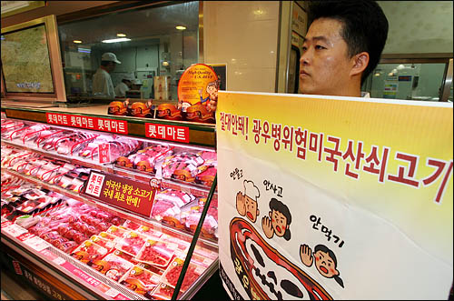 한미FTA에 반대하는 단체 회원들이 지난해 7월 13일 오전 미국산 쇠고기 판매를 시작한 롯데마트 서울역지점 수입육 코너에서 "광우병 위험이 있는 미국산쇠고기 수입 판매 반대"를 외치며 강력 반발하고 있다.